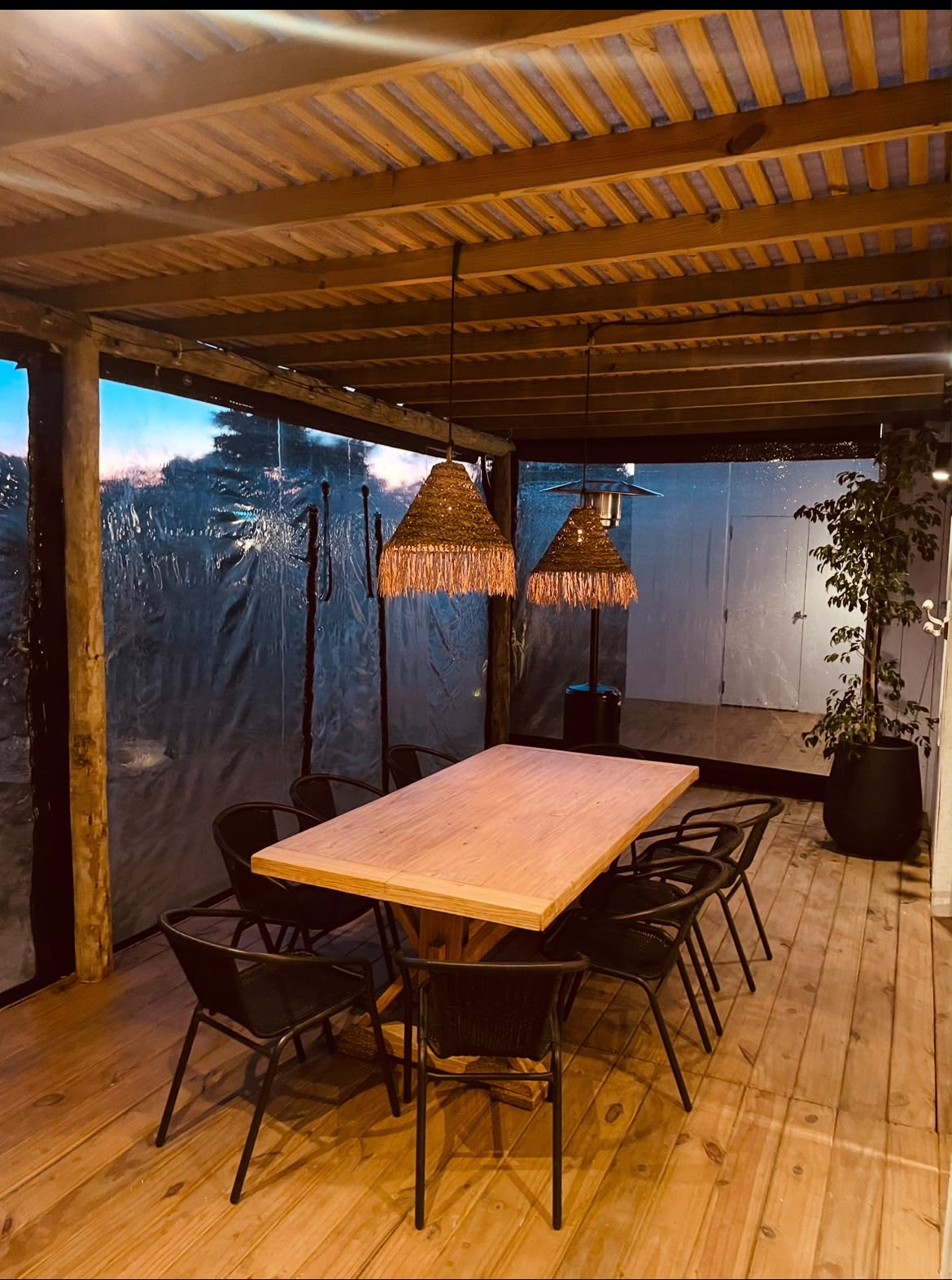 Mesa del deck iluminada con lámparas de fibra al atardecer